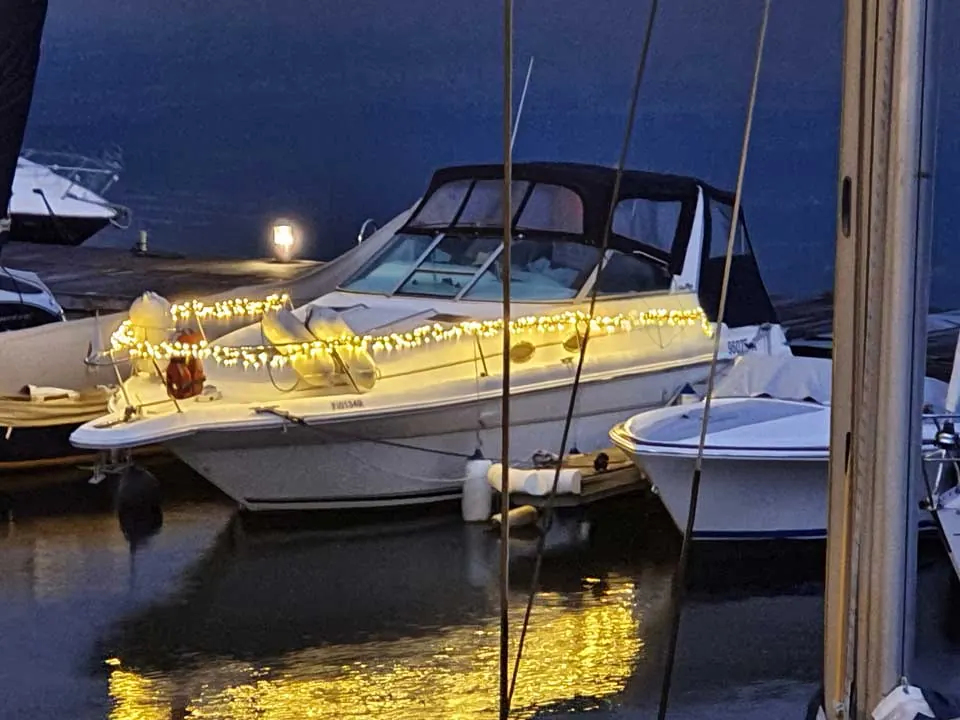 Lichtinstallation an einem Boot am Steg – illuminierte Bootspartie